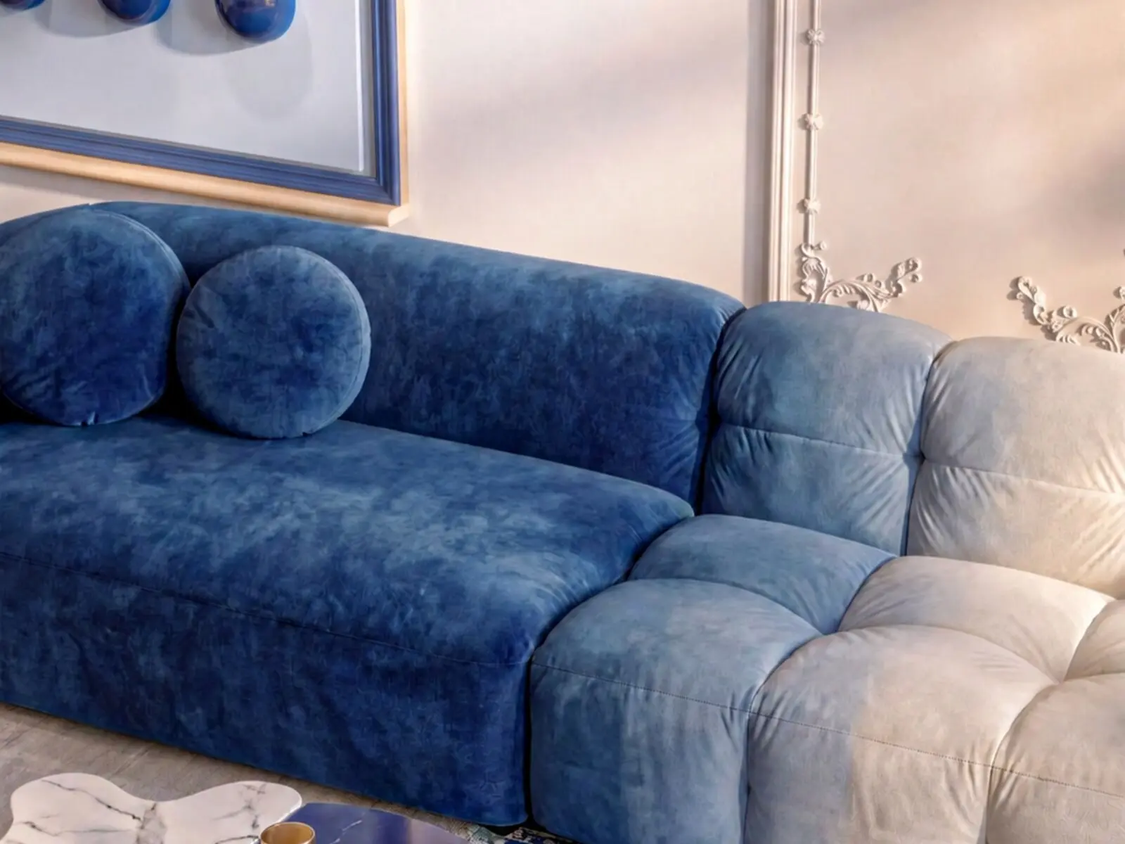 Détail du canapé modulable bleu et blanc et des tables en marbre