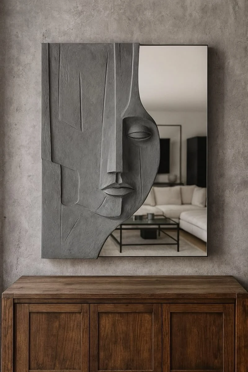 Miroir avec visage sculpté gris au-dessus d’un meuble en bois